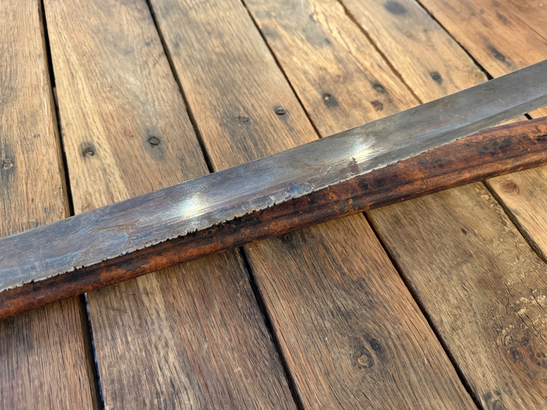 Close-up of the blade edge showing deep V-shaped indentations from combat