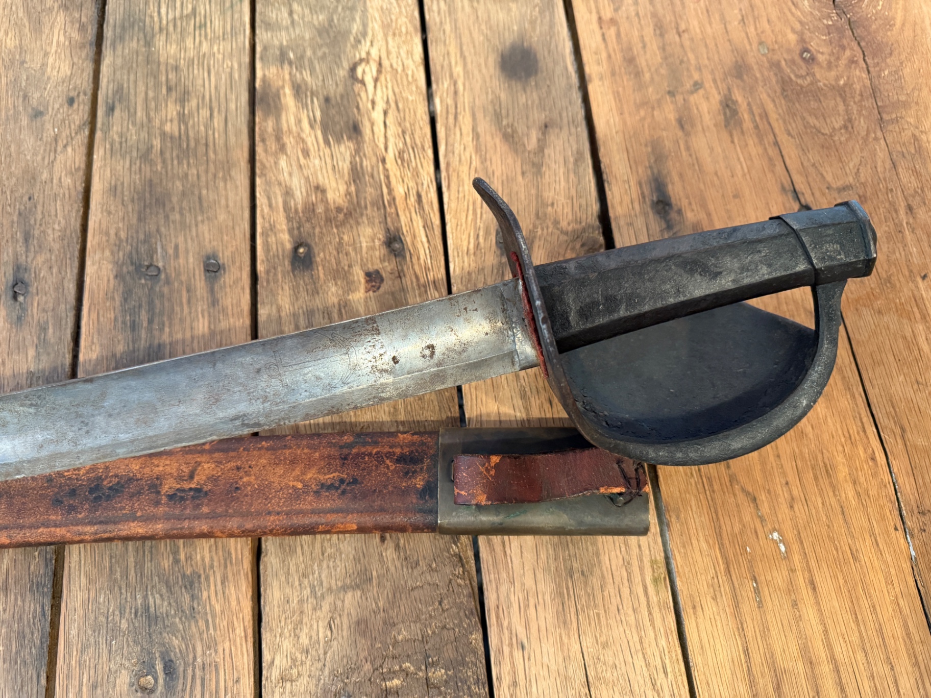 Close-up of the cutlass hilt and a stamped mark on the blade